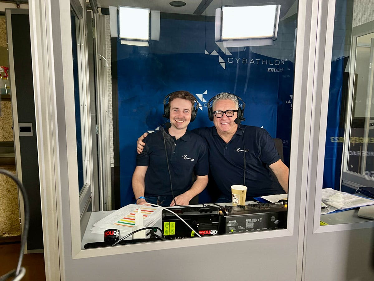 Patrick and Nick Fellows are seated in the commentators' booth, attentively watching the race and providing live commentary, sharing their expert insights and analysis of the Vision Assistance Race with the audience.